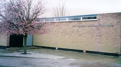 Outside of the 14th Midlothian Bonnyrigg Scout Hall, a single-storey brick building with a flowering tree in front
