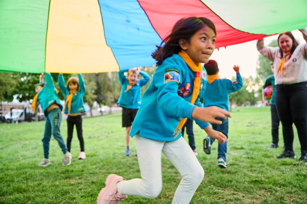 Scout volunteer playing a parachute game with Beavers