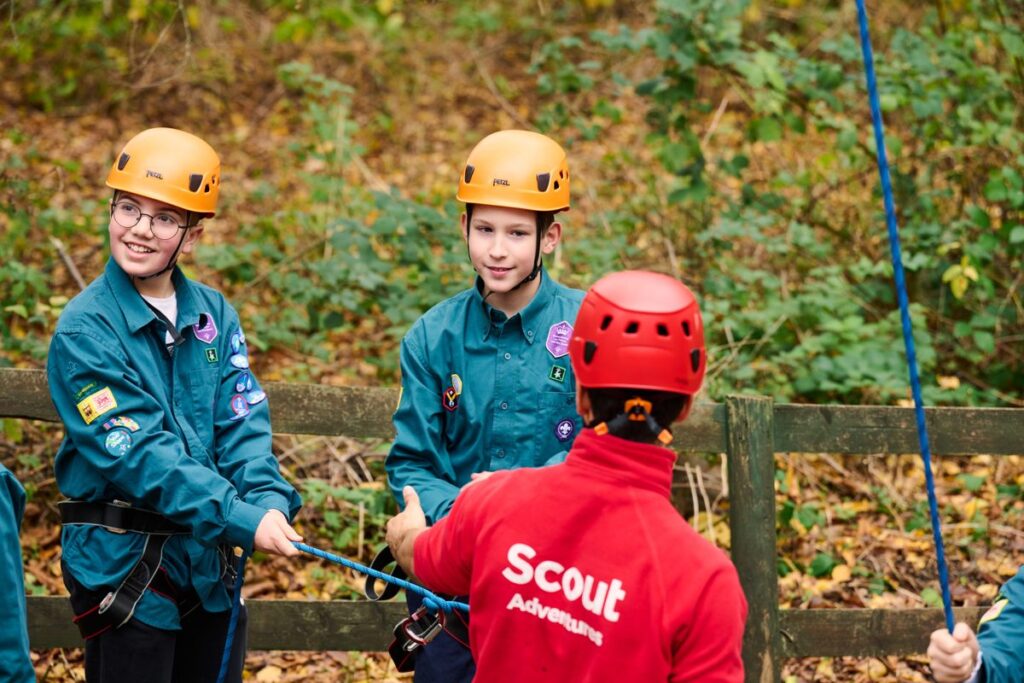 Scout volunteer with Scouts on an abseil